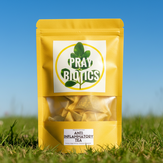 Yellow package of 'Pray Botics' tea on grass with a clear blue sky